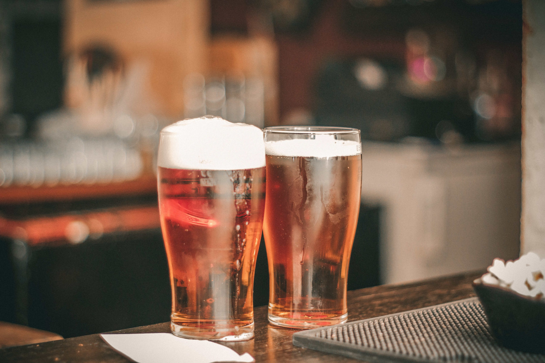 Beer glasses sitting on a bar.