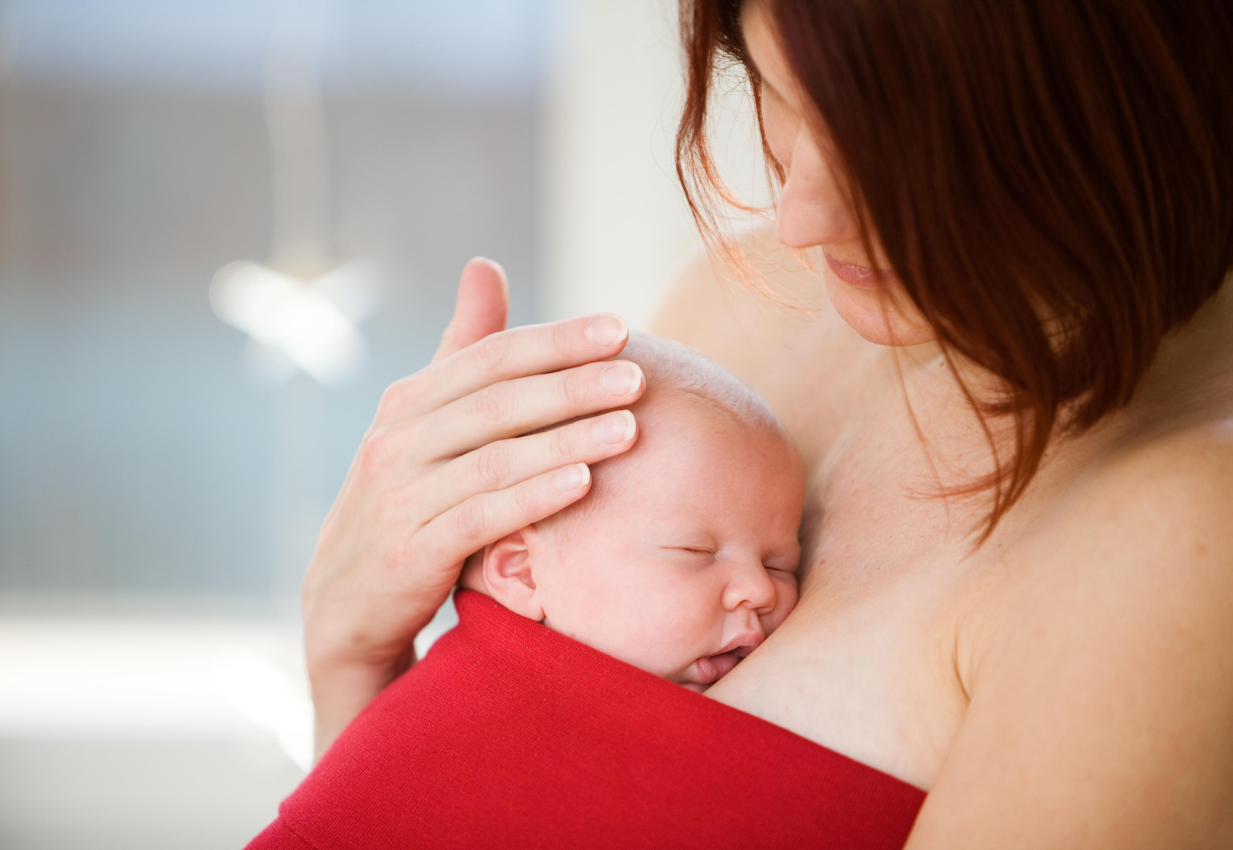 Newborn lays on mother's chest for skin-to-skin contact and kangaroo mother care.