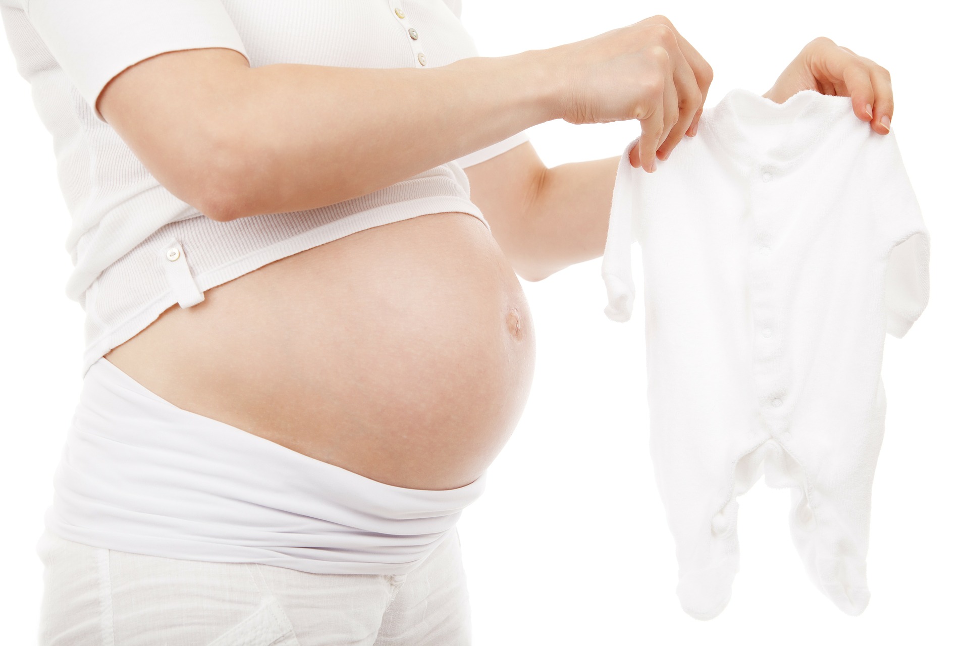 Pregnant woman folding baby clothes. Baby bottle campaigns are becoming popular fundraisers for babies in need.