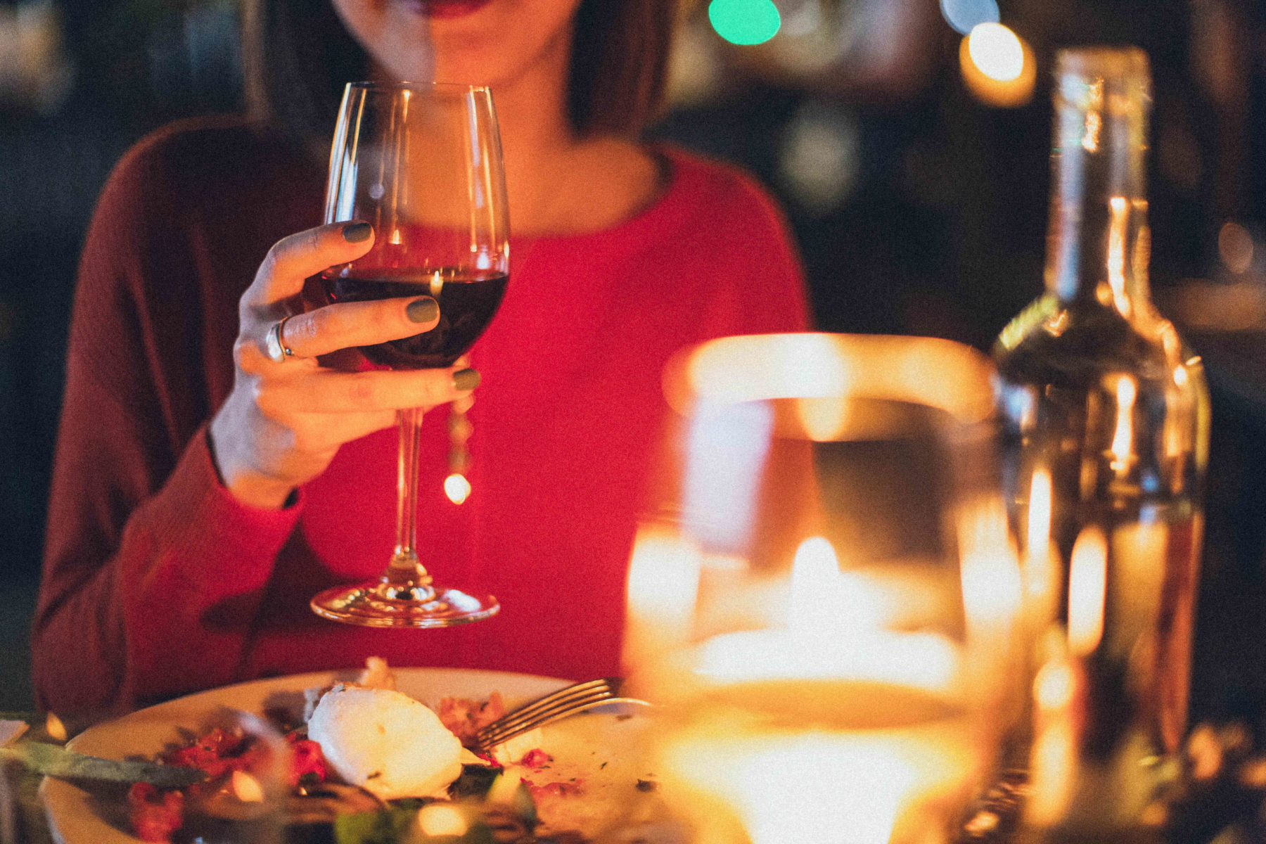 Woman drinking wine at a meal.