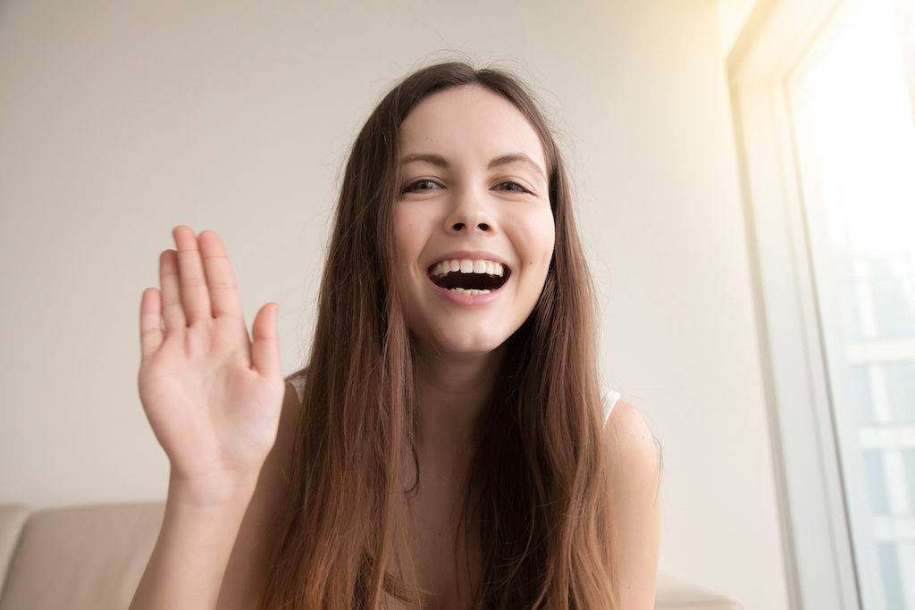 Smiling woman raising hand