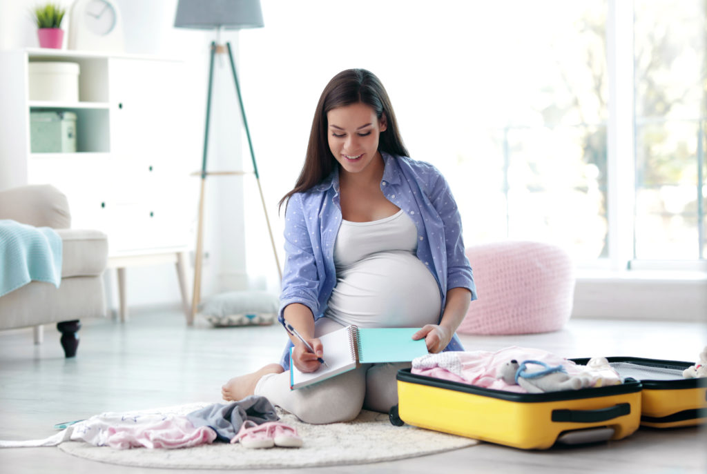 Brunette woman preparing bag before going to the hospital.