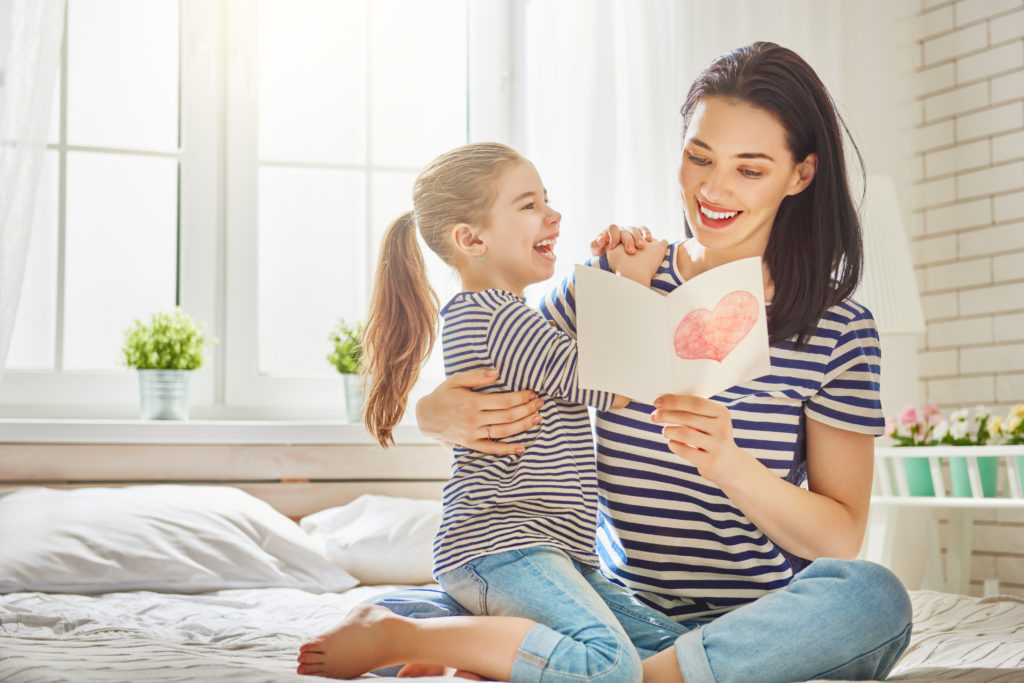 Little girl celebrating mom with card