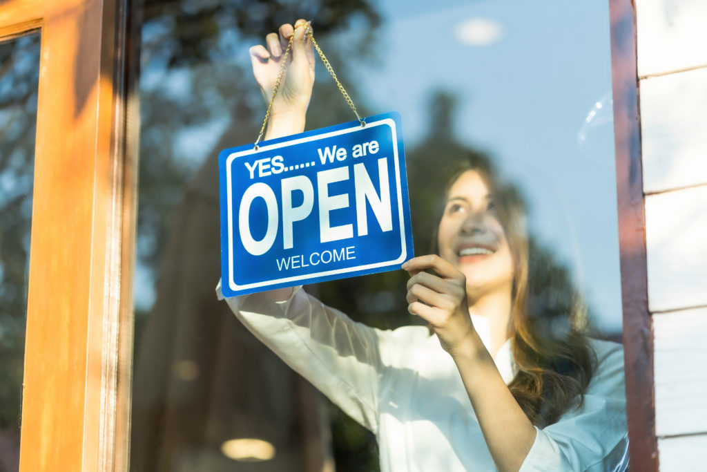 Woman hanging open sign