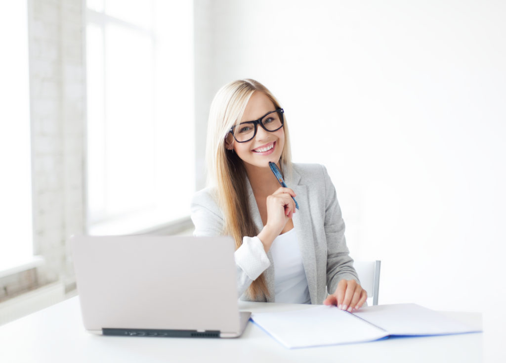 Woman in glasses with laptop and notebook