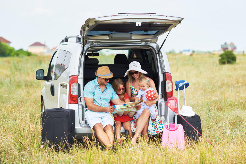 Family with suitcases on road trip with a nursing baby.