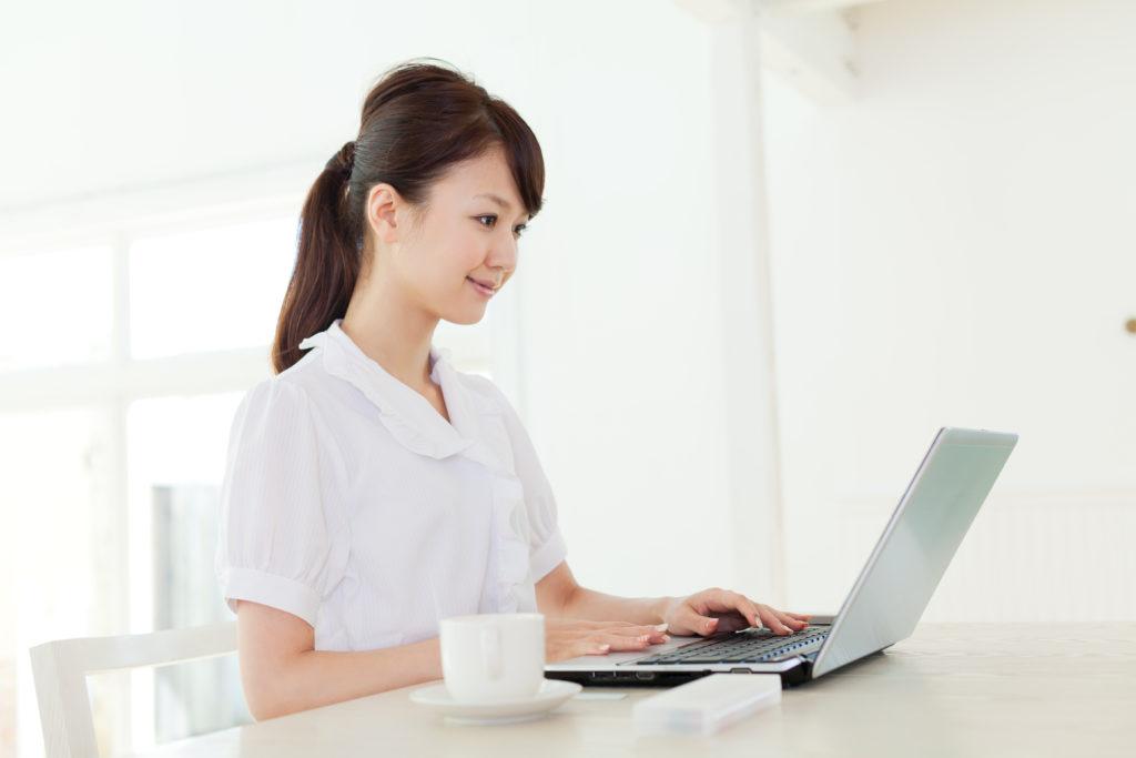 Woman with laptop computer and mug.