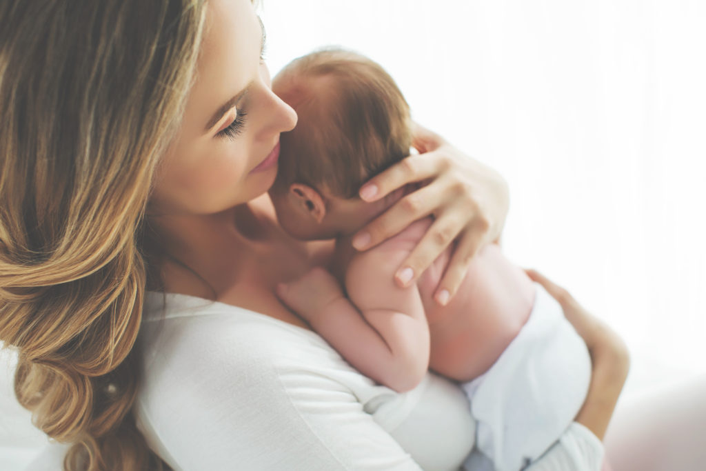 Blonde woman holding newborn baby