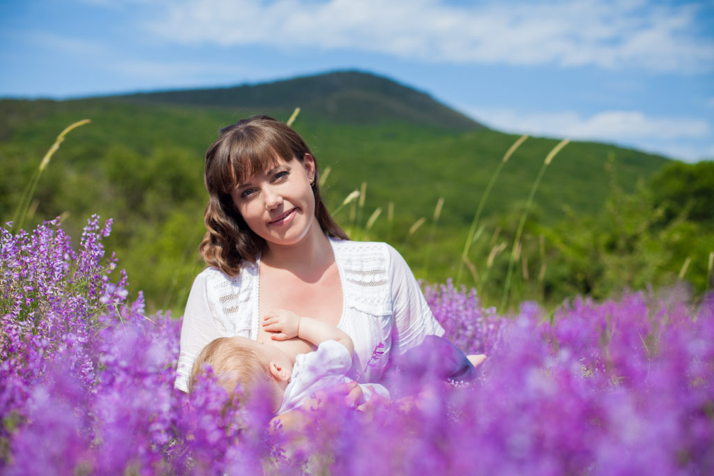 Women in field of purple flowers breastfeeding in support of a healthier planet