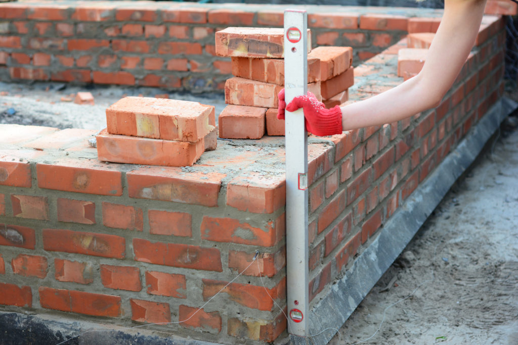 Woman laying bricks to create a firm foundation.