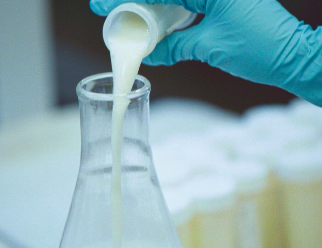 Pouring banked human milk into a flask.