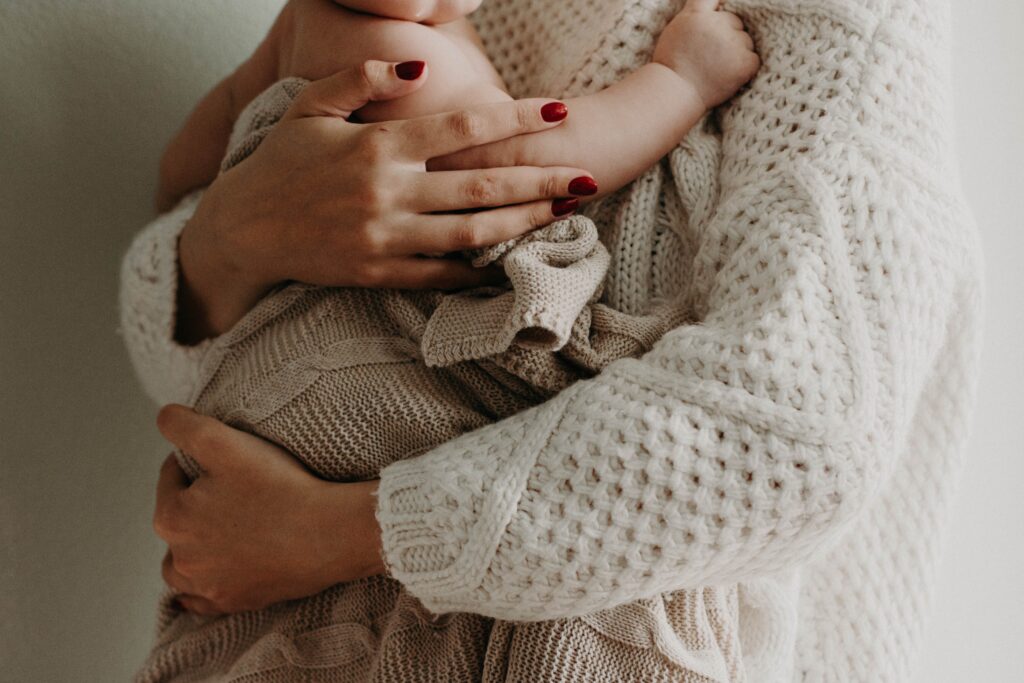 Mom in white sweater holding baby