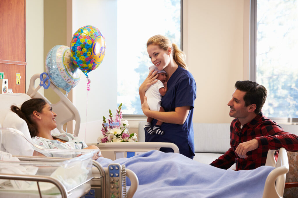 New parents with healthcare worker and baby in hospital.