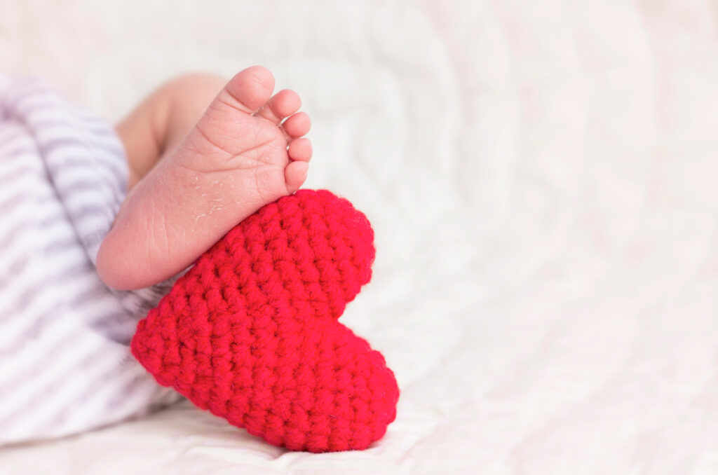 Baby feet with a red heart