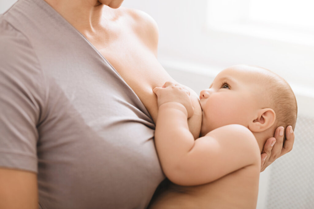 Mother in brown shirt breastfeeding baby.