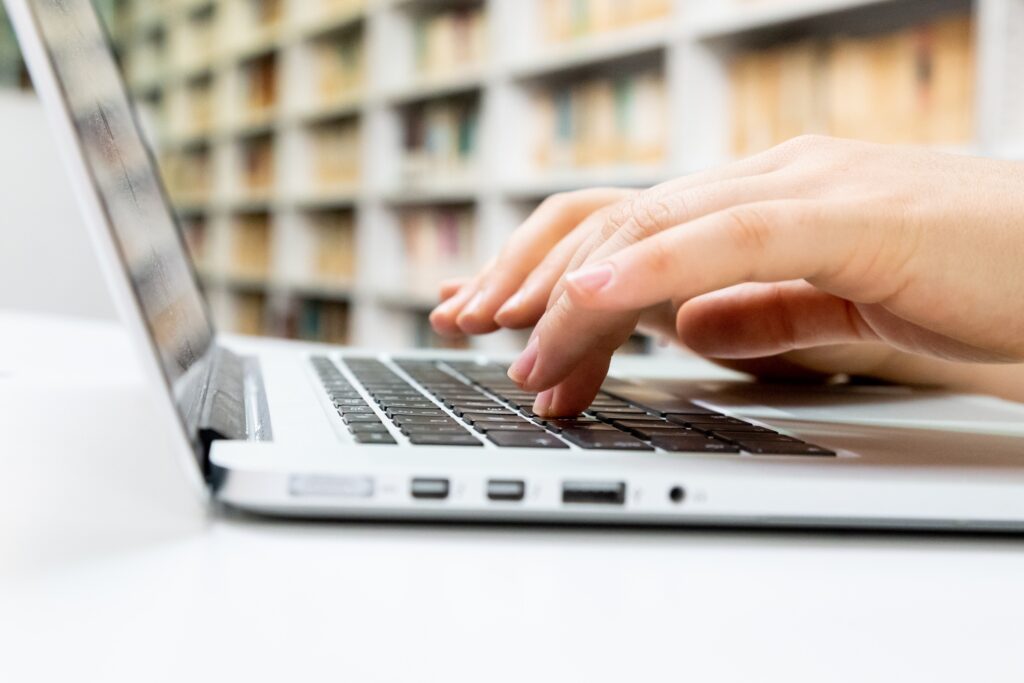 Fingers typing on a laptop keyboard.