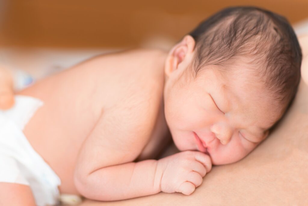 Baby in diaper laying skin to skin.