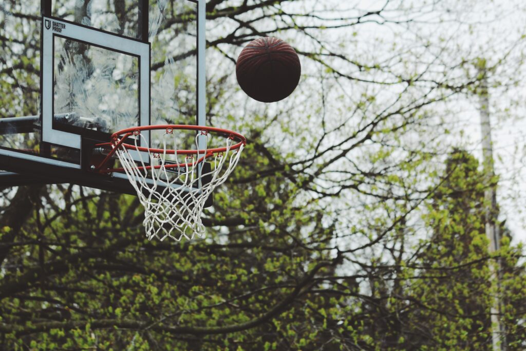 Basketball in mid-air near hoop. 