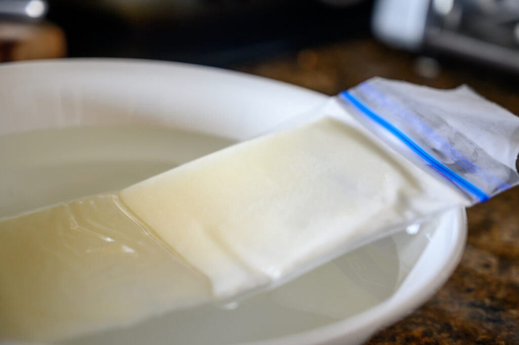 Milk storage bag thawing in a bowl of water.