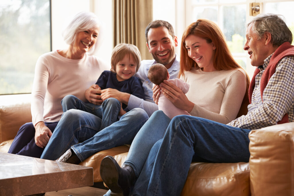 Famly sitting on couch with newborn; all have a responsibility to protect breastfeeding.