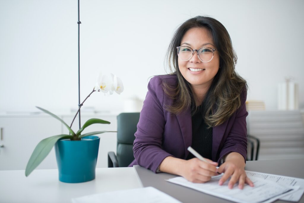 Woman in purple blazer at desk of a successful business.