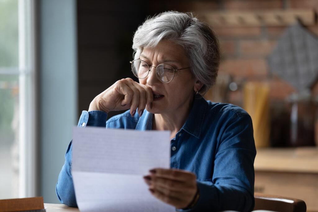 Woman studying test scores nervous about losing her job. 