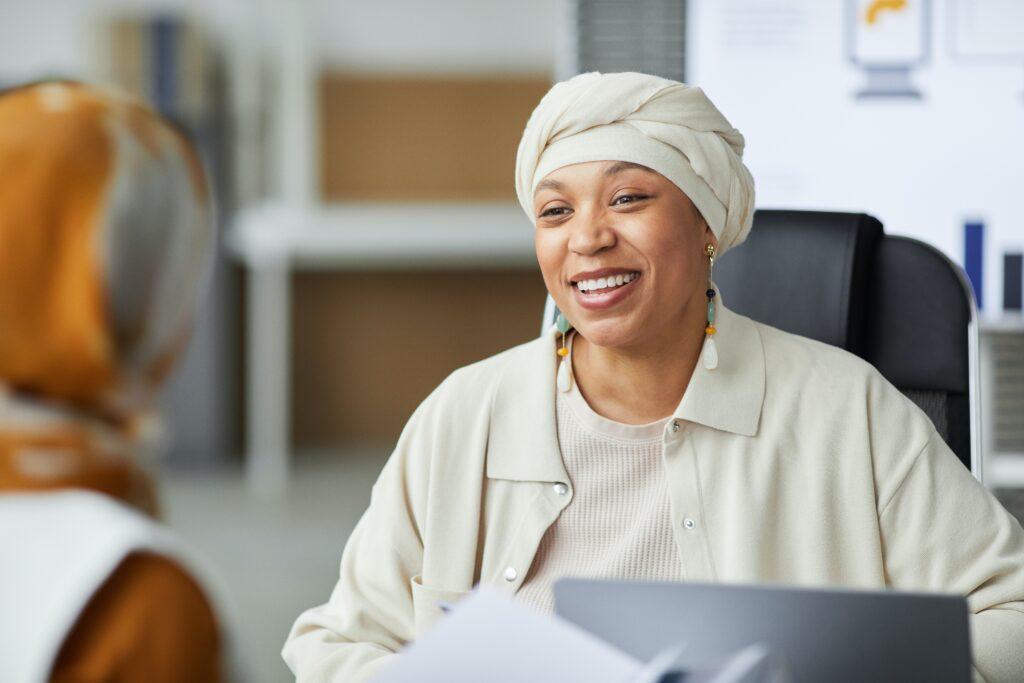 Two women in discussion at a desk.