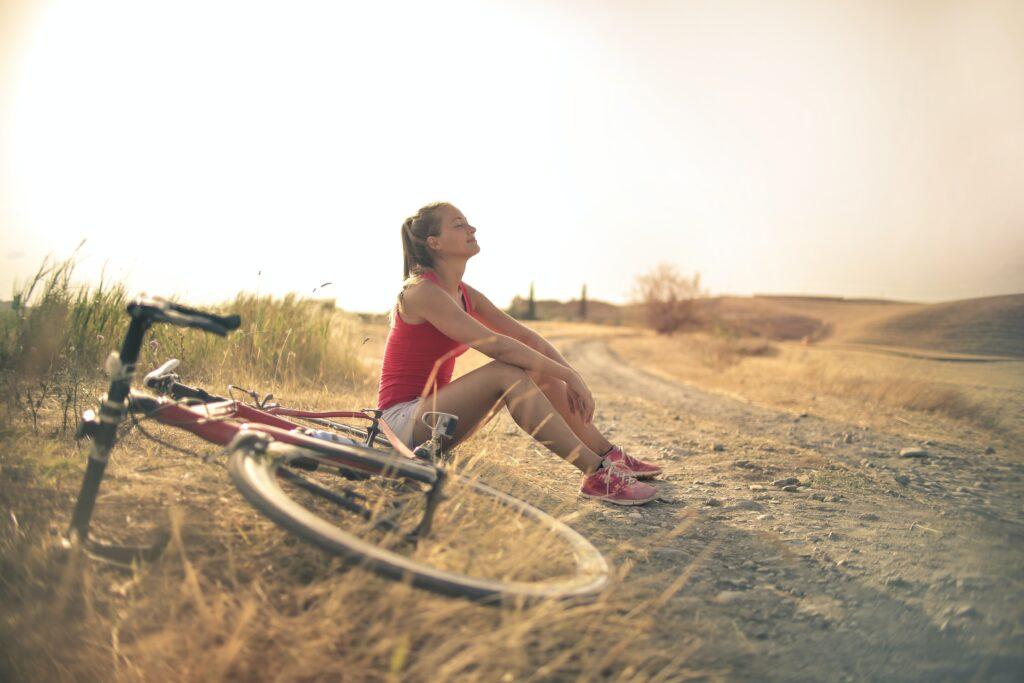 Woman sitting next to a bike with eyes closed visualizing.