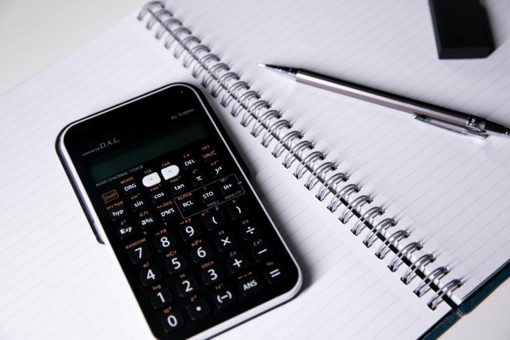 Calculator and pencil on notebook.