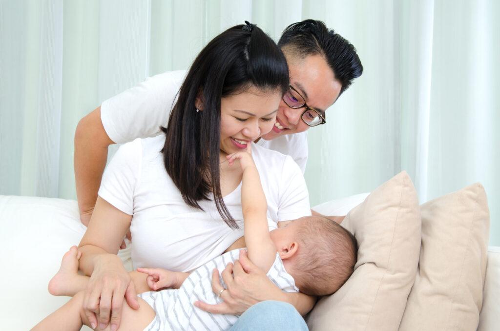 Dad supporting mom breastfeeding infant.