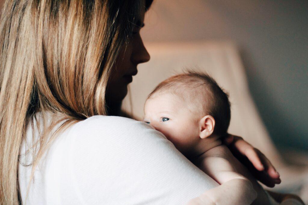 Newborn on mother's shoulder.