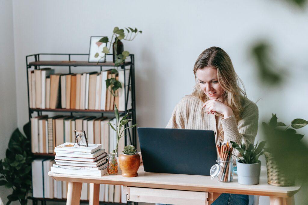 Woman looking at laptop in a home office looking for information about breastfeeding.