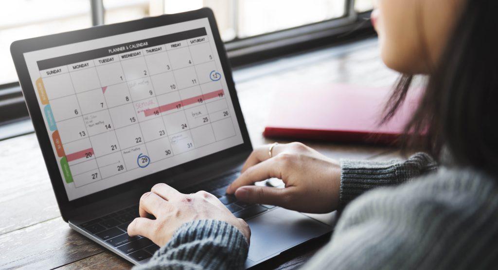 Laptop computer with calendar filled with dates and highlights.
