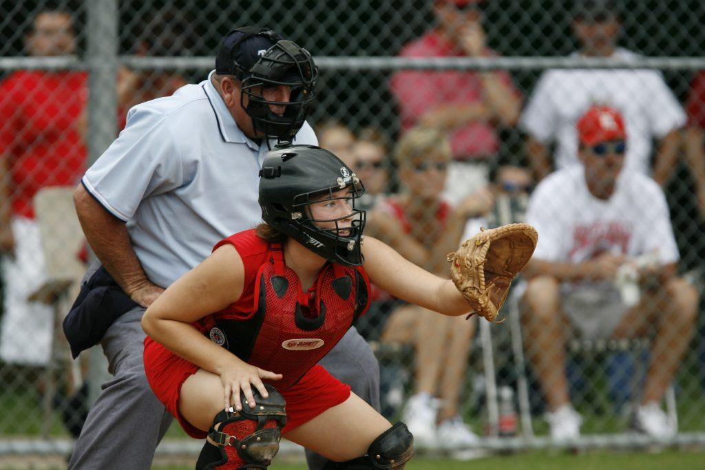 Catcher wearing red uniform in front of umpire.